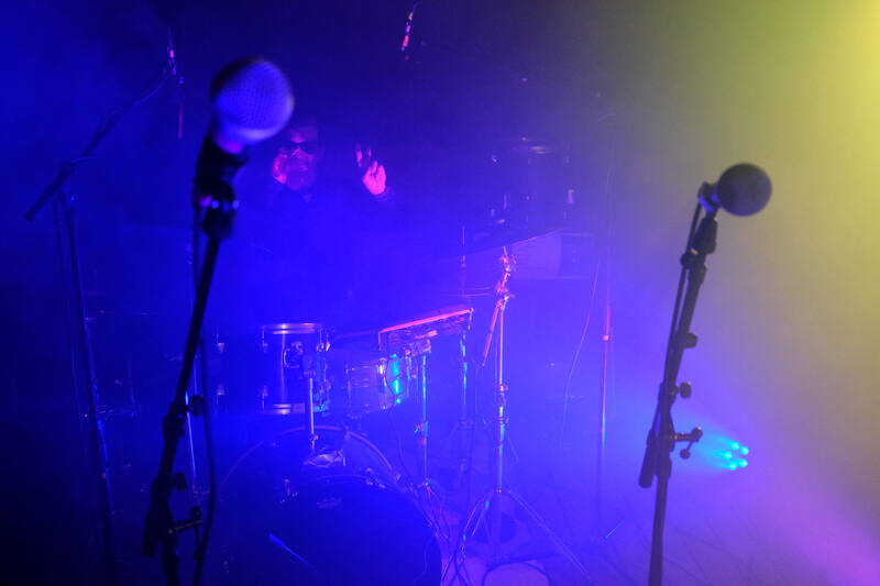 Drum kit and microphones in blue and yellow light